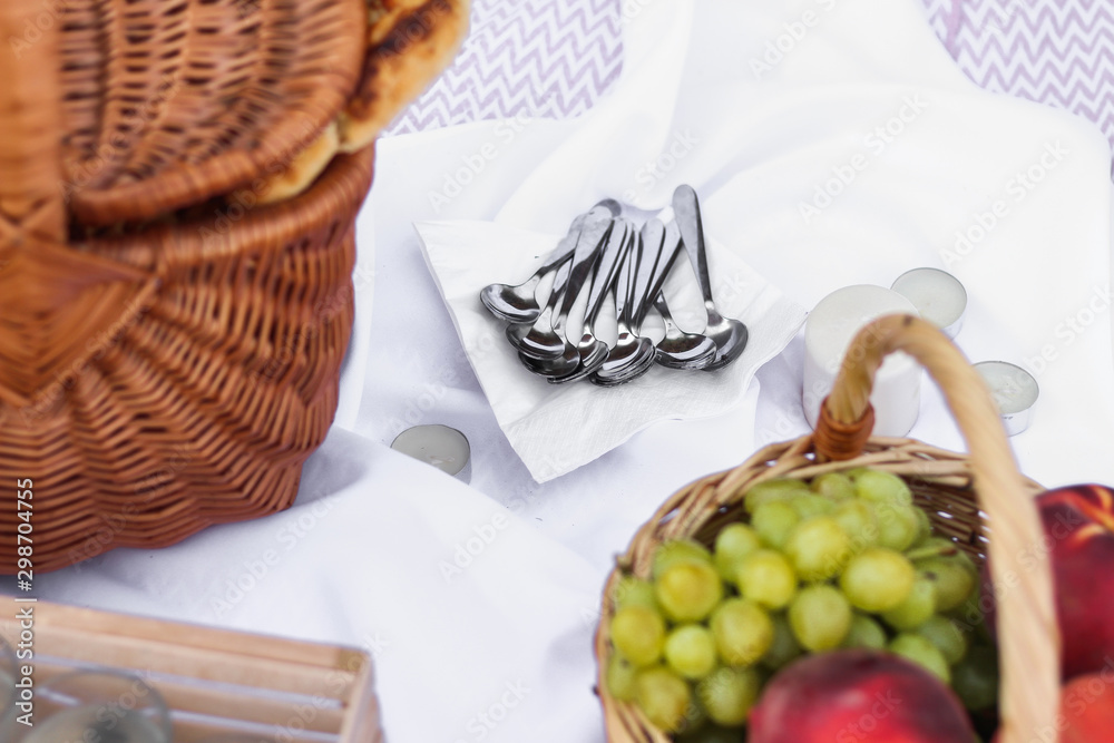 Wicker picnic basket with food and a white tablecloth on the sand at the beach. picnic background concept.