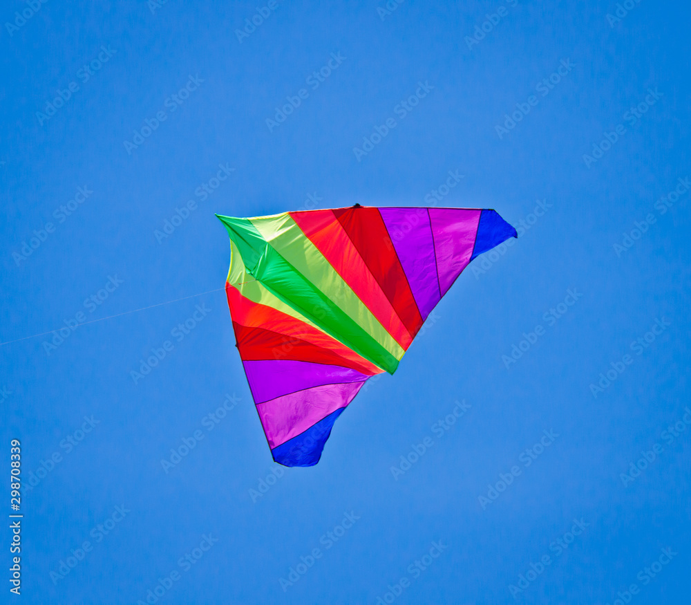 A beautiful, colourful stunt kite, in the blue sky, high up in the wind A beautiful, colourful stunt kite, in the blue sky, high up in the wind