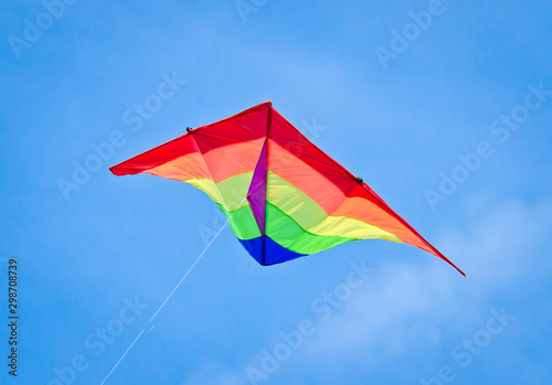 Tableau sur toile A beautiful, colourful stunt kite, in the blue sky, high up in the wind