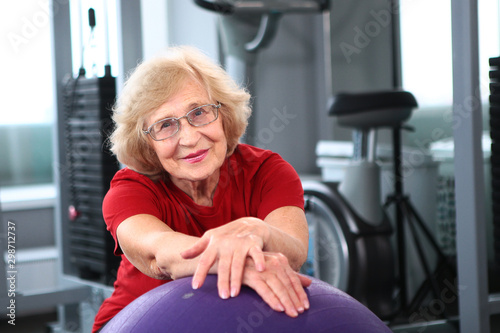 An elderly woman goes in for sports. Classes with a ball for fittes. Retired healthy and active lifestyle concept.