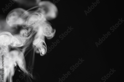 Fototapeta Naklejka Na Ścianę i Meble -  White smoke on a black background. Texture of smoke. Clubs of white smoke on a dark background for an overlay