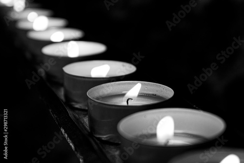 Black and White Macro Image of Candles in a line / row with Dark Background and Bokeh 