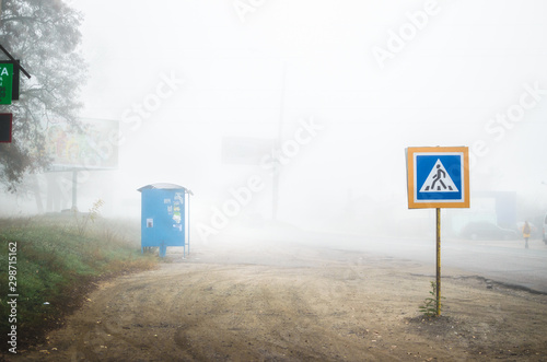 Bus stop and pedestrian sign in the fog photo