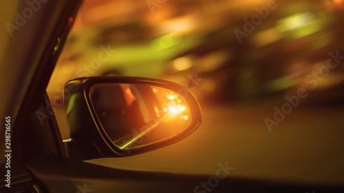 car side mirror and traffic light from vehicle headlights at night © Bonsales