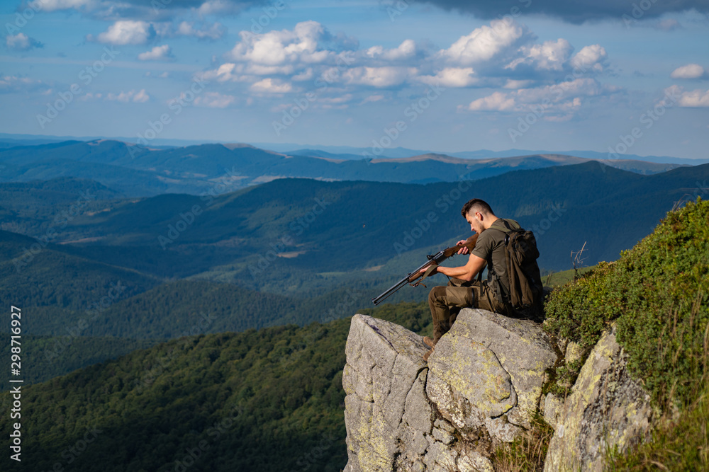 Man hunter with a gun. Hunter with his rifle. Hunting in Russia. Process of duck hunting. A hunter with a hunting gun hunt in summer forest. Hunting - Men hobby.