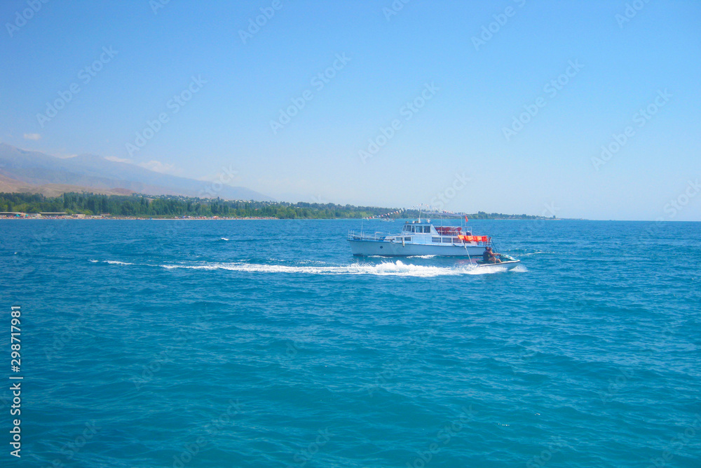 Jet ski in the sea on a Sunny day on the handicap of a small motor ship