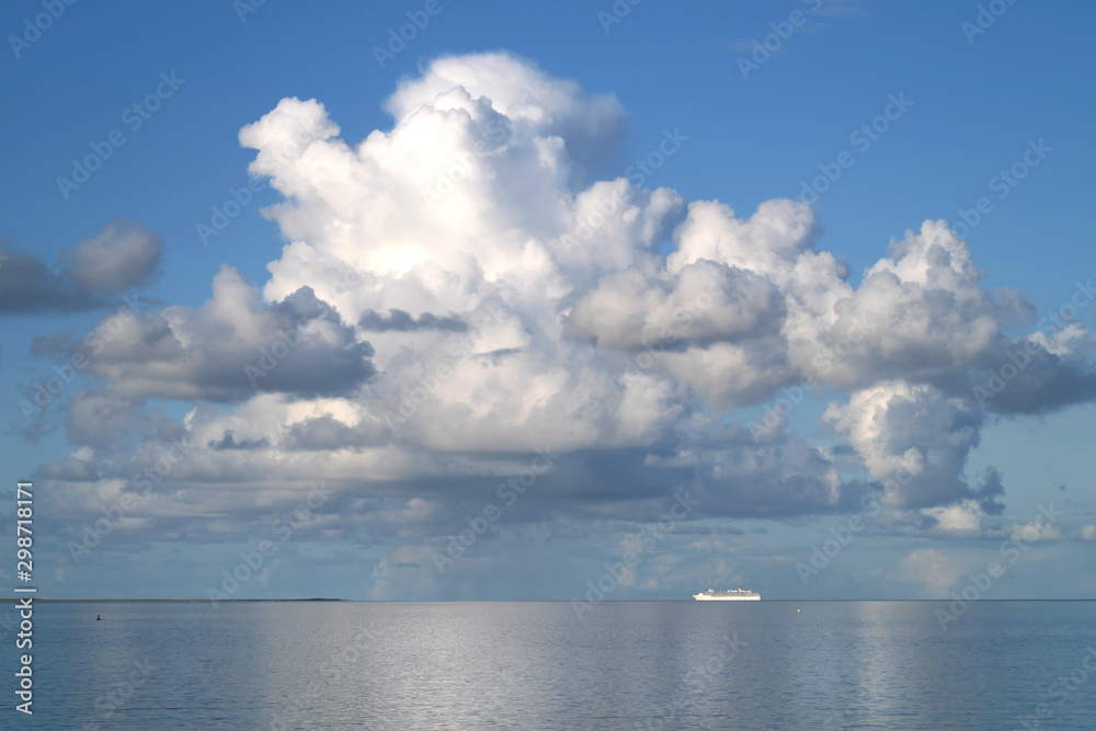 Kreuzfahrtschiff am Horizont verlässt Bremerhaven über die Nordsee und blauer Himmel mit weißen Wolken - Stockfoto