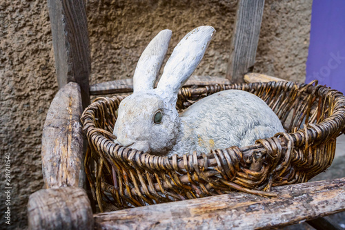 Obraz na płótnie Ancienne figurine de lapin blanc dans le panier. Décoration vintage extérieur.. w salonie