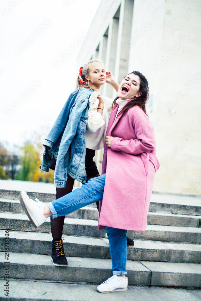young happy students teenagers at university building on stairs, lifestyle people concept brunette and blond girl