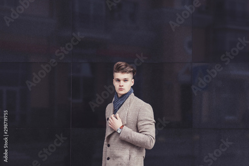 Foto a serious man in a stylish coat against the wall