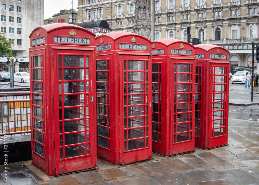 four (4)red telephone boxes in London in a row four (4)red telephone boxes in London in a row