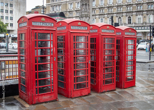 four (4)red telephone boxes in London in a row © alan