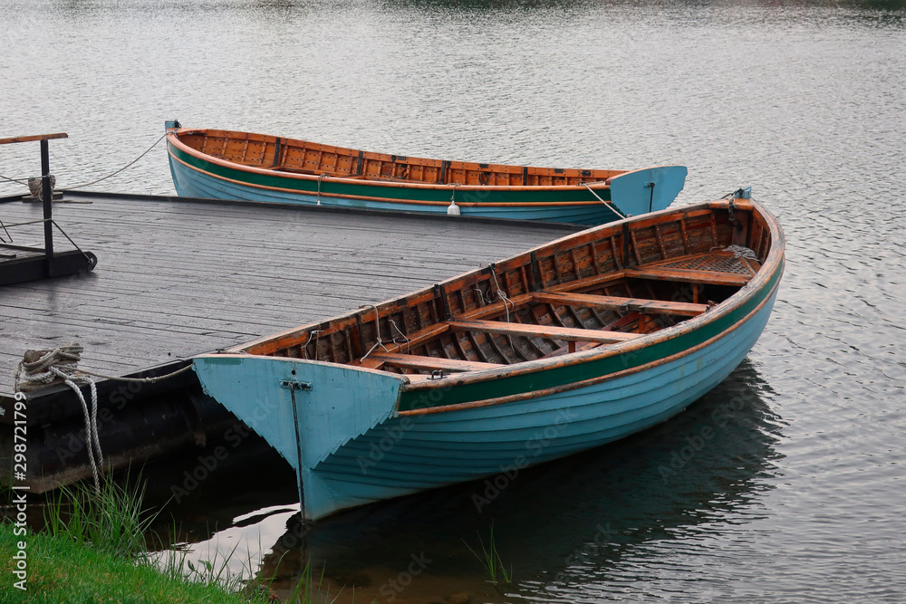 two boats moored at a boardwalk on the lake