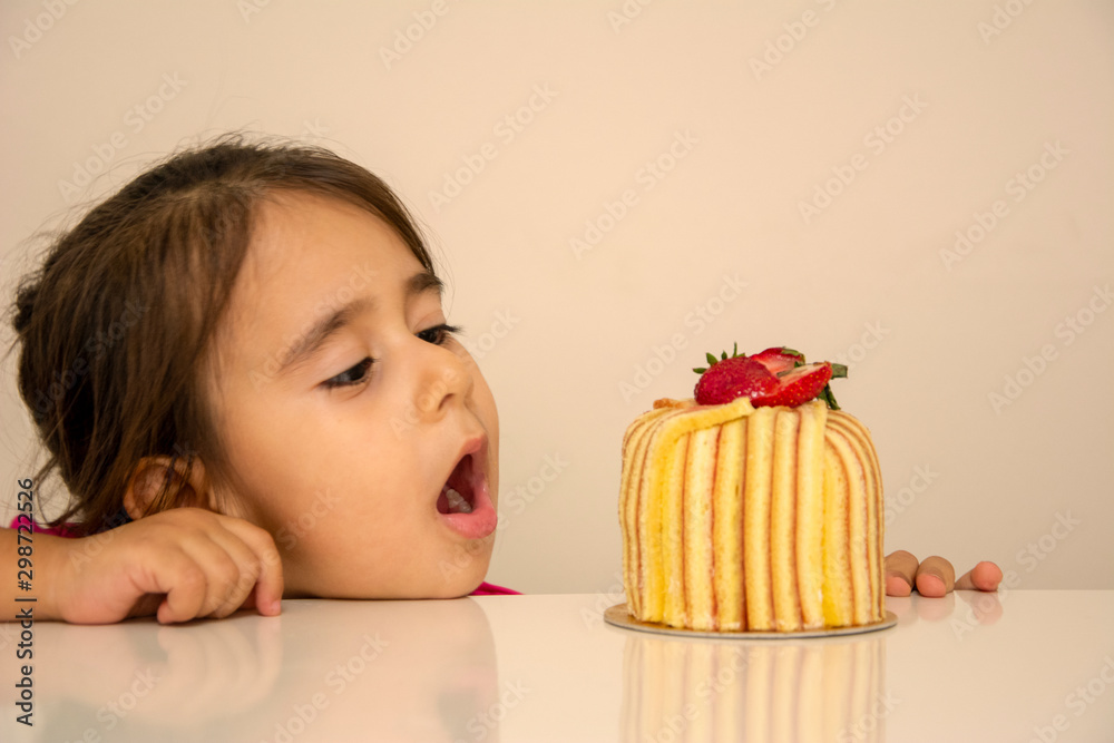 Little girl looking at cake and is surprised Little girl looking at cake and is surprised
