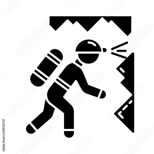 Spelunking glyph icon. Caving, potholing. Exploring underground caverns. Equipped spelunker, caver. Walking, climbing in caves. Silhouette symbol. Negative space. Vector isolated illustration
