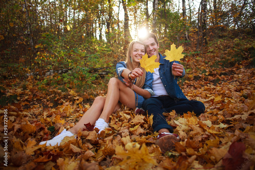 Loving happy young couple in forest park in autumn on nature at sunset background