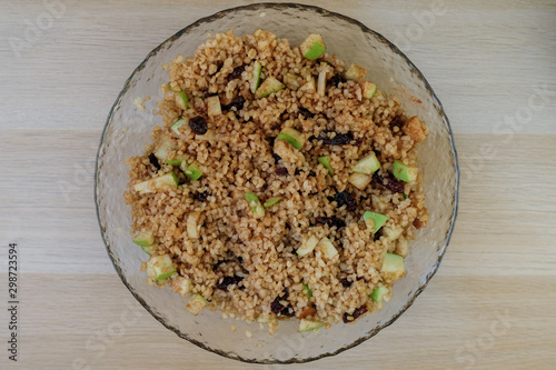 Cooked bulgur with raisins, apples, cinnamon and sugar. Sweet bulgur porridge, vegetarian food.