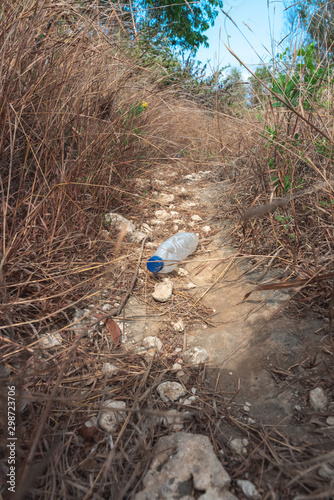 plastic bottle single use waste on a hiking trail