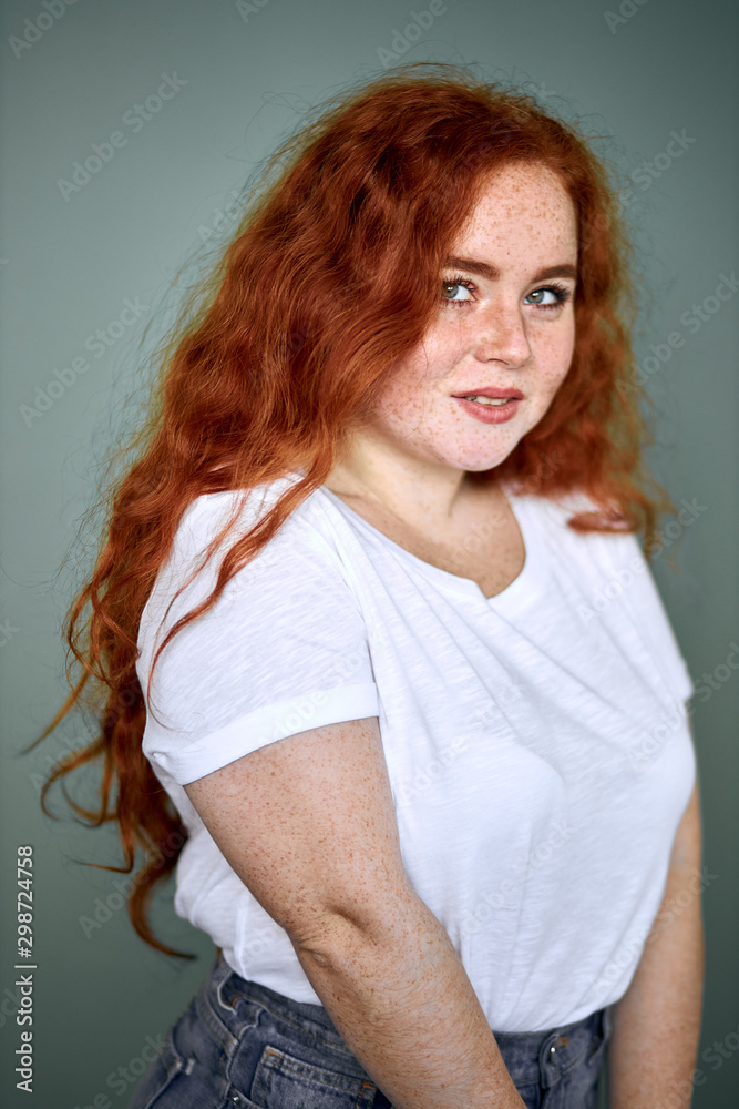 Young caucasian girl with red hair wearing white t-shirt and shorts,  posing, look at camera. Red curly long hair, model, plus size Stock Photo |  Adobe Stock