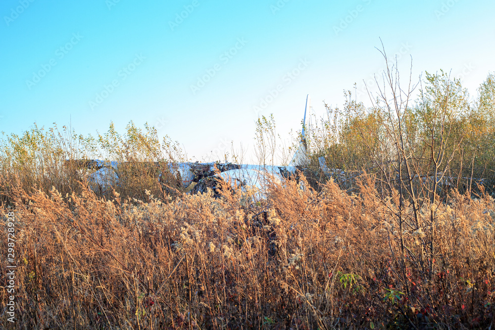 Broken plane in field at sunset. Crashed plane after accident Broken plane in field at sunset. Crashed plane after accident