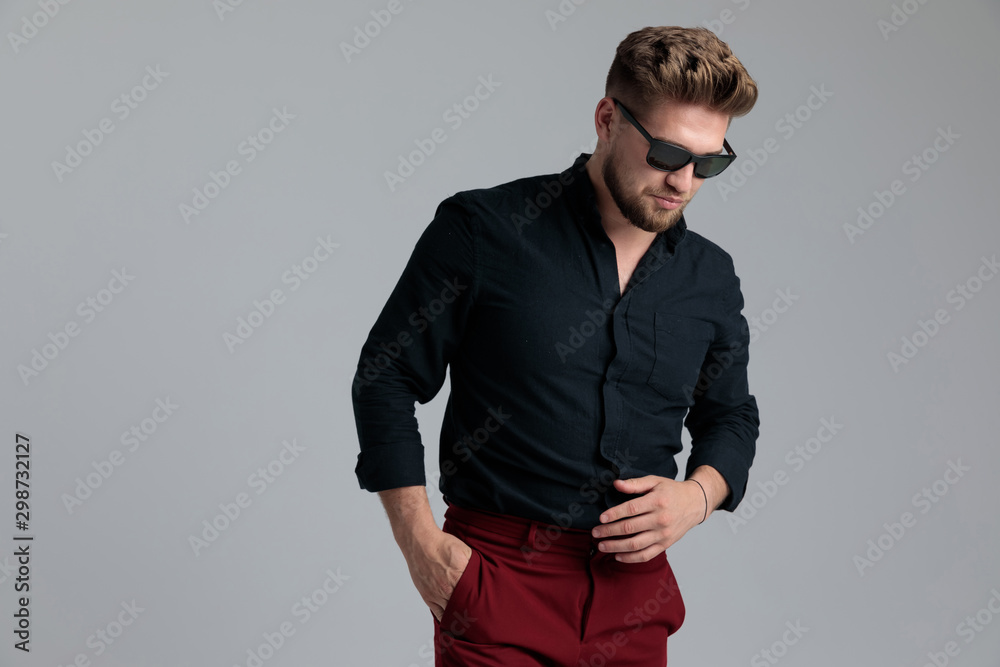 Fototapeta premium Wondering fashion man holding his hand in his pocket