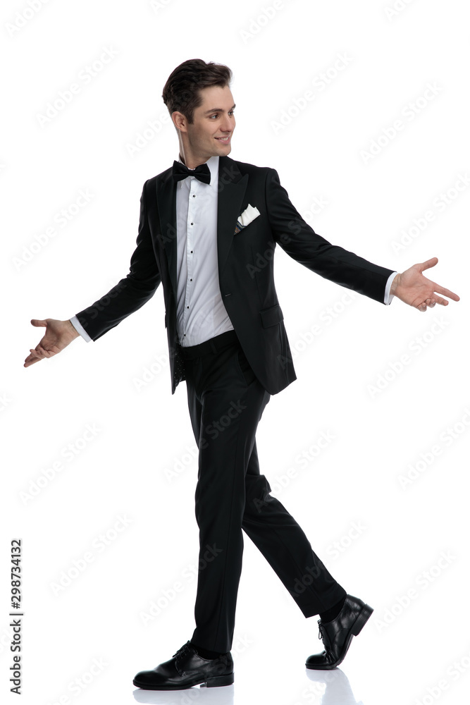 side view of young elegant man walking and opening arms side view of young elegant man walking and opening arms