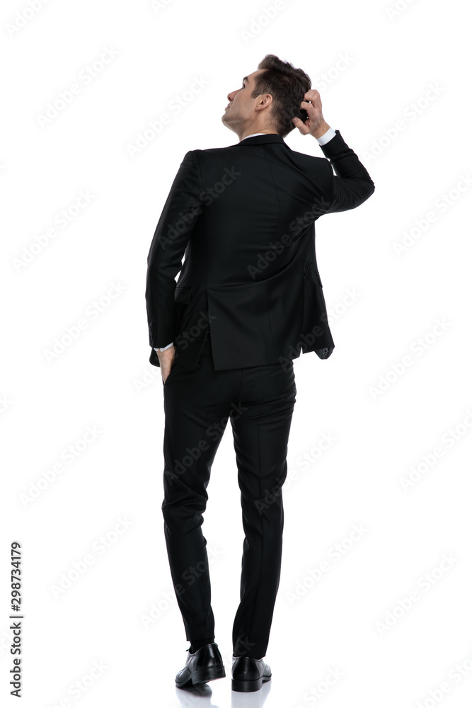 back view of young model scratching head and looking up back view of young model scratching head and looking up