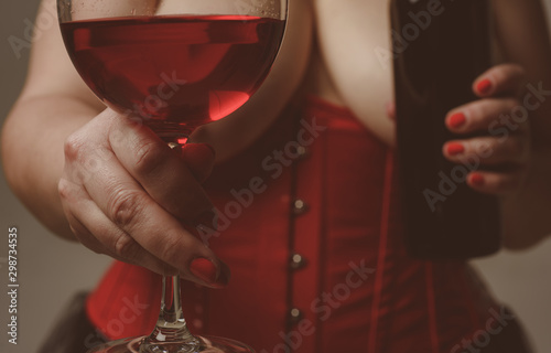 love date. erotic games. woman in corset with sexy chest drink red wine. alcohol drink. Sexy reality. lets celebrate. Perfect body in sexy lingerie. cheers. to us. Sexy female fetish-wear. Hot babe