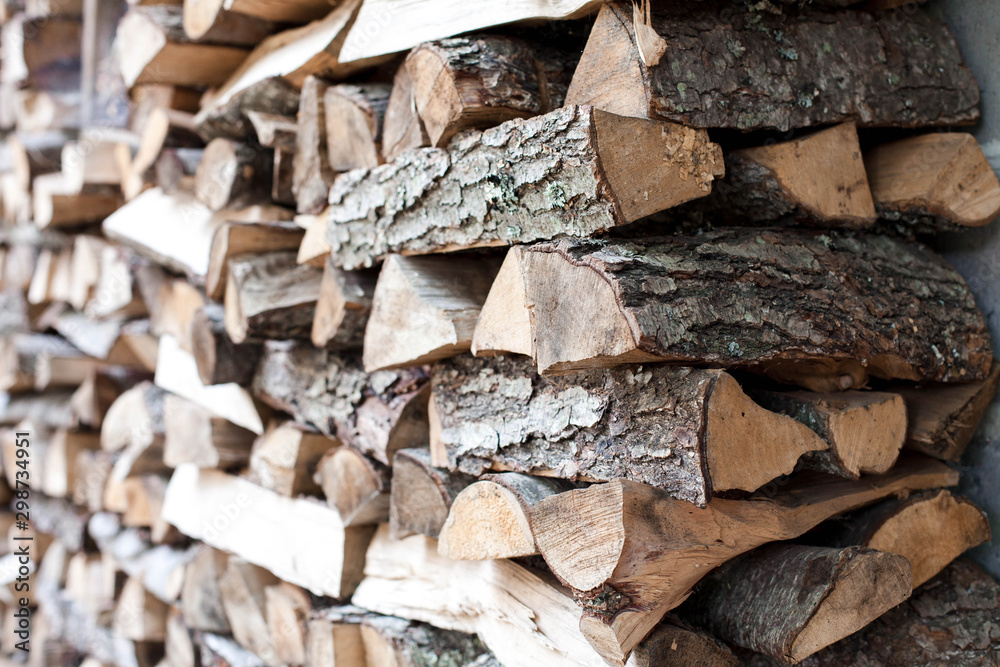 Woodpile of firewood by house. Chipped firewood laying. Preparation for winter. Close up. Woodpile of firewood by house. Chipped firewood laying. Preparation for winter. Close up.