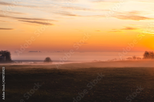 Beautiful golden sunrise. Morning dawn with fog in the fall.