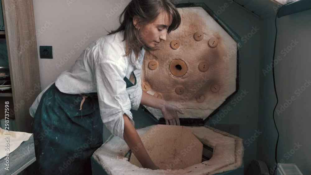 potter preparing the pottery kiln for the baking process for her dish