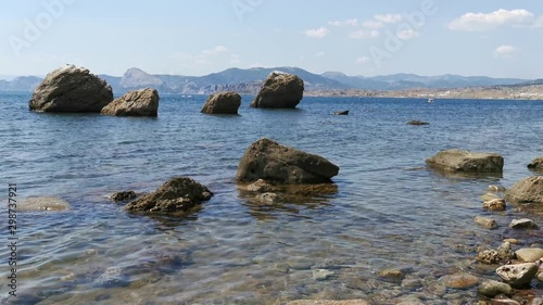 Stone beach, waves and big stones in the sea. 4K realtime video