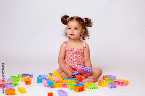 baby girl playing with multicolored constructor, isolate, space for text