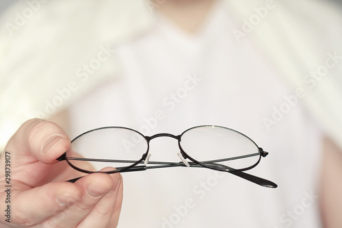 The concept of poor vision. Hold a contact lens and glasses in hand. A poster for advertising glasses and lenses.