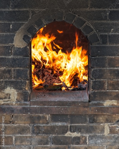 Fireplace made of bricks and some items burning in the fire