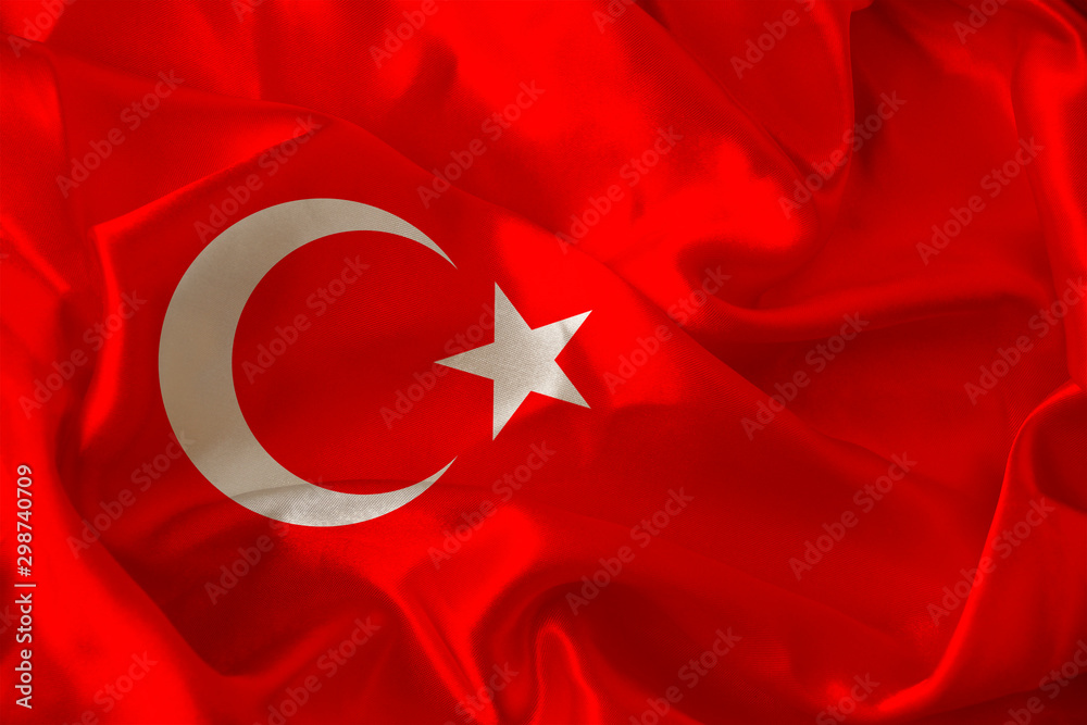photo of beautiful colored national flag of modern state of Turkey on textured fabric, concept of tourism, emigration, economy and politics, closeup