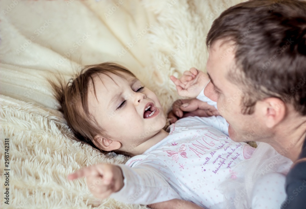 Dad plays with the baby in bed Dad plays with the baby in bed