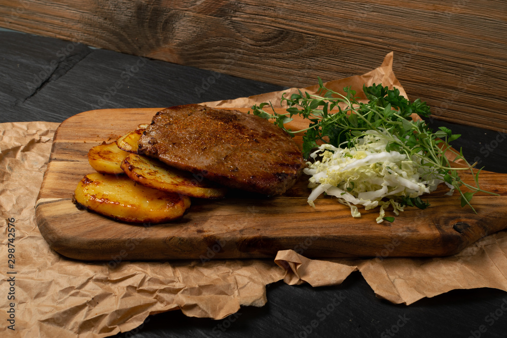 Grilled chivas beef steak with coleslaw, fried potatoes and greens Grilled chivas beef steak with coleslaw, fried potatoes and greens