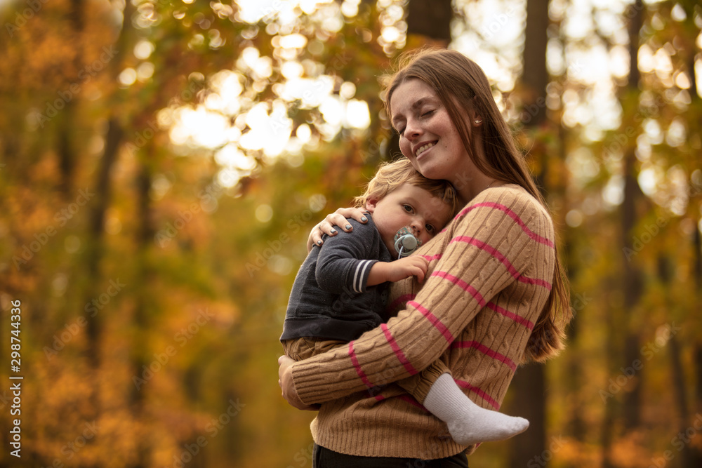 Happy mother with her beautiful baby in the autumn park. Lifestyle. Mom and son. Sunny day. Happy mother with her beautiful baby in the autumn park. Lifestyle. Mom and son. Sunny day.