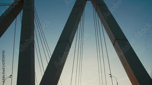 auto drives along cable-stayed Millennium bridge at sunset photo