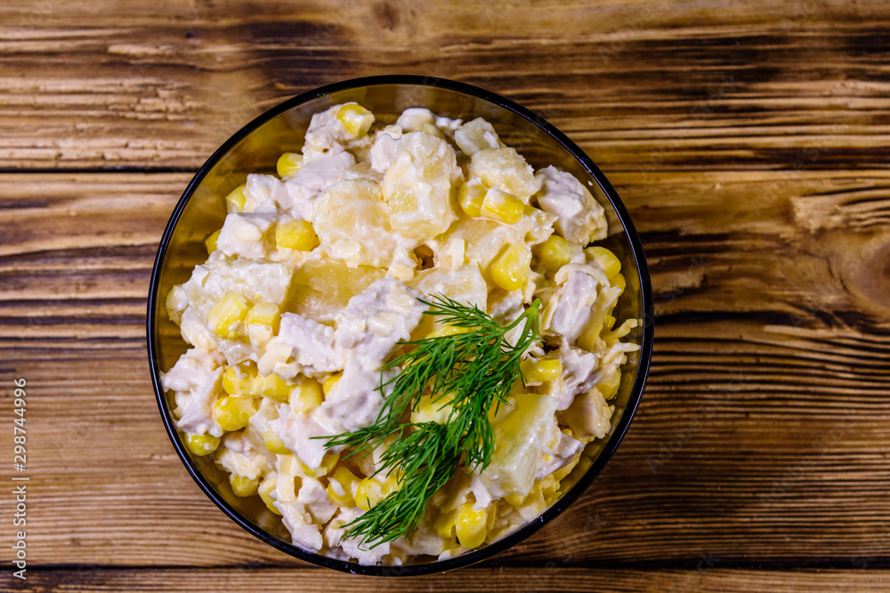 Festive salad with chicken breast, canned pineapple, cheese, sweet corn and mayonnaise on wooden table. Top view Festive salad with chicken breast, canned pineapple, cheese, sweet corn and mayonnaise on wooden table. Top view