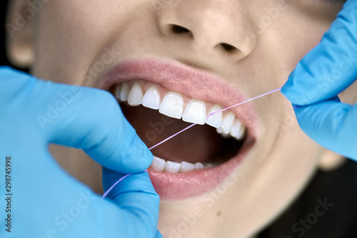 Pretty woman's teeth cleaning in dental clinic