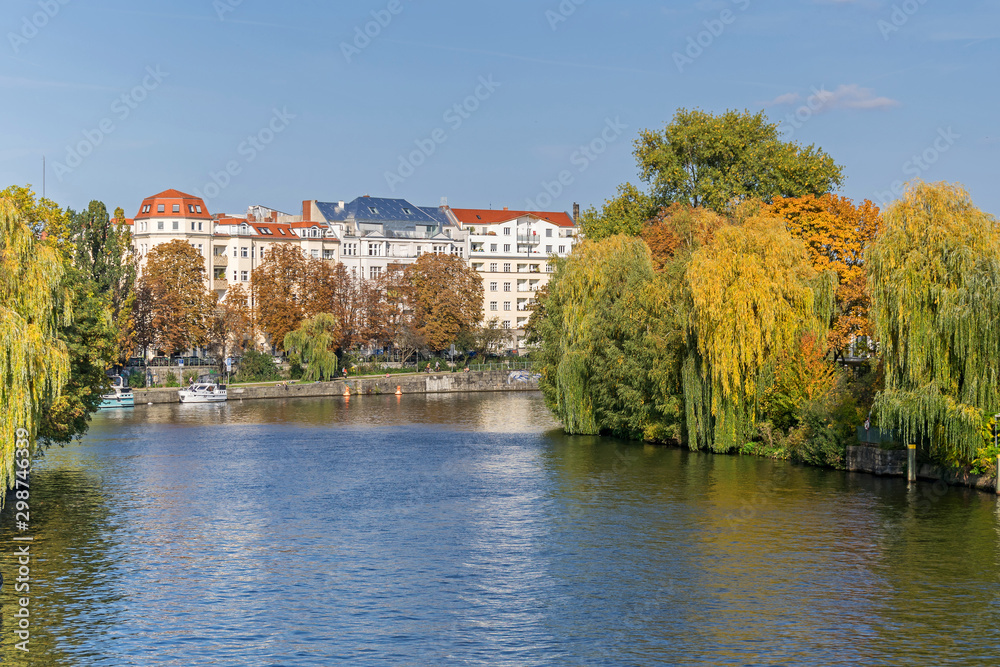 Banks of the river Spree with autumn coloured trees and residential buildings at Bundesratufer in Berlin