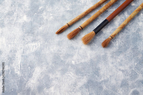 Set of brushes Fude for Sumi-e painting. Bright wooden background. Top view. Copy space. 