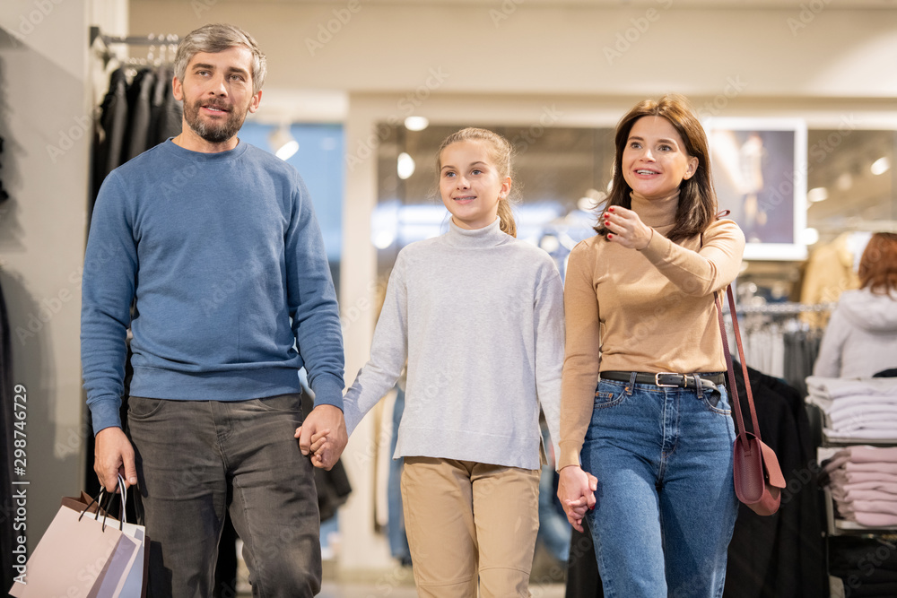 Young woman showing her daughter and husband seasonal collection that is on sale Young woman showing her daughter and husband seasonal collection that is on sale