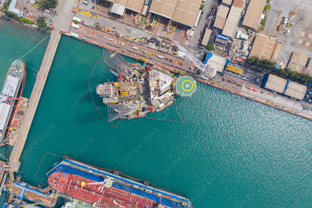 Aerial view of a jack up oil drilling rig and dry dock ship in the shipyard for maintenance