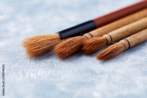 Set of brushes Fude for Sumi-e painting. Bright wooden background. Top view. Copy space. 