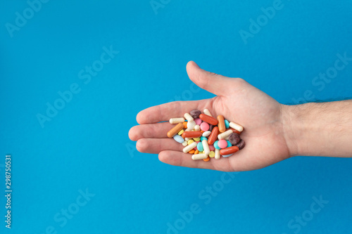 A handful of colored pills on the palm. Medical concept. Shopping at the pharmacy.