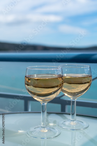 White wine served outside on balcony on glass table with sea view