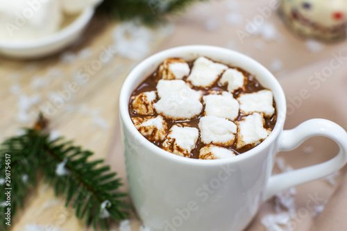 hot cocoa with marshmallows in white mug, cream and cookies on holiday christmas background.